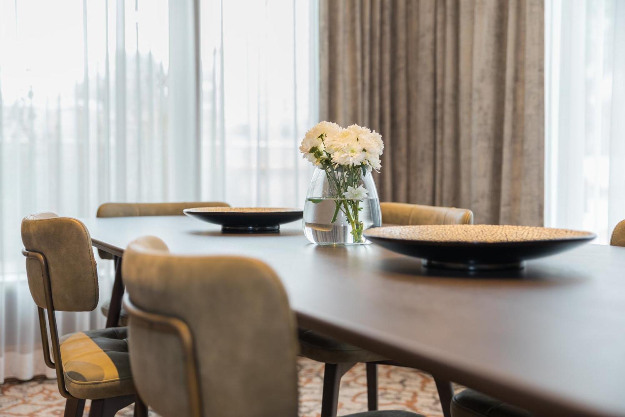 ホテル クラウンプラザ ポルト エクステリア 写真 A dining room table with a vase of flowers